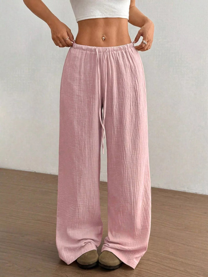 Pink crinkled wide leg pants, close front view of the tie waist