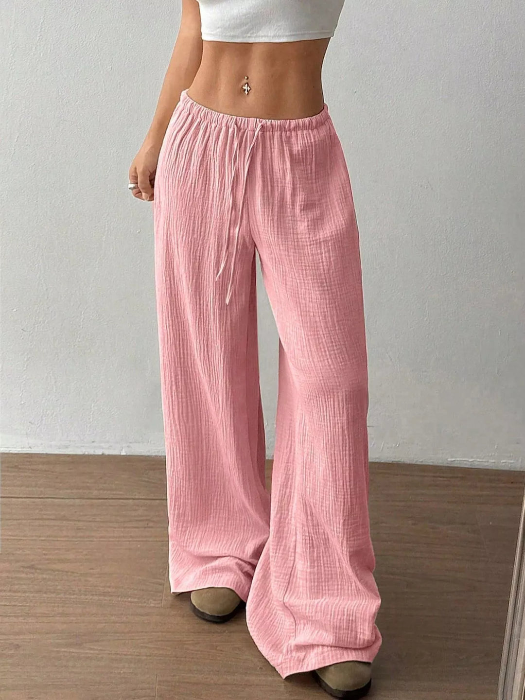 Pink wide leg pants with drawstring waist, front view with cropped white top