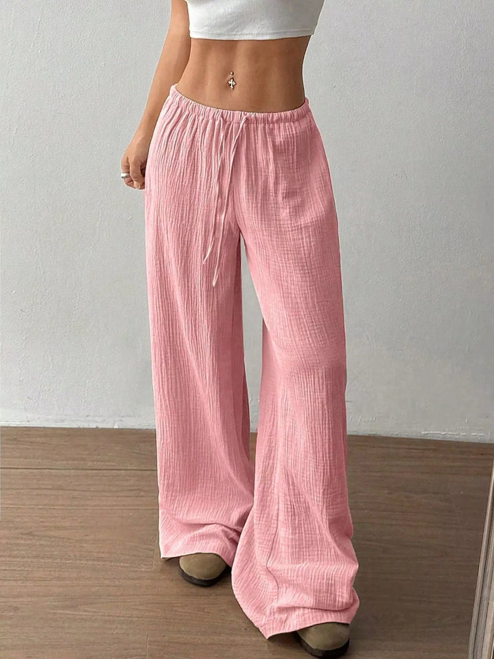 Pink wide leg pants with drawstring waist, front view with cropped white top