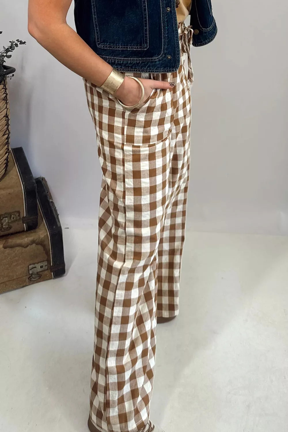 Close-up of the brown plaid patch pocket and drawstring waist