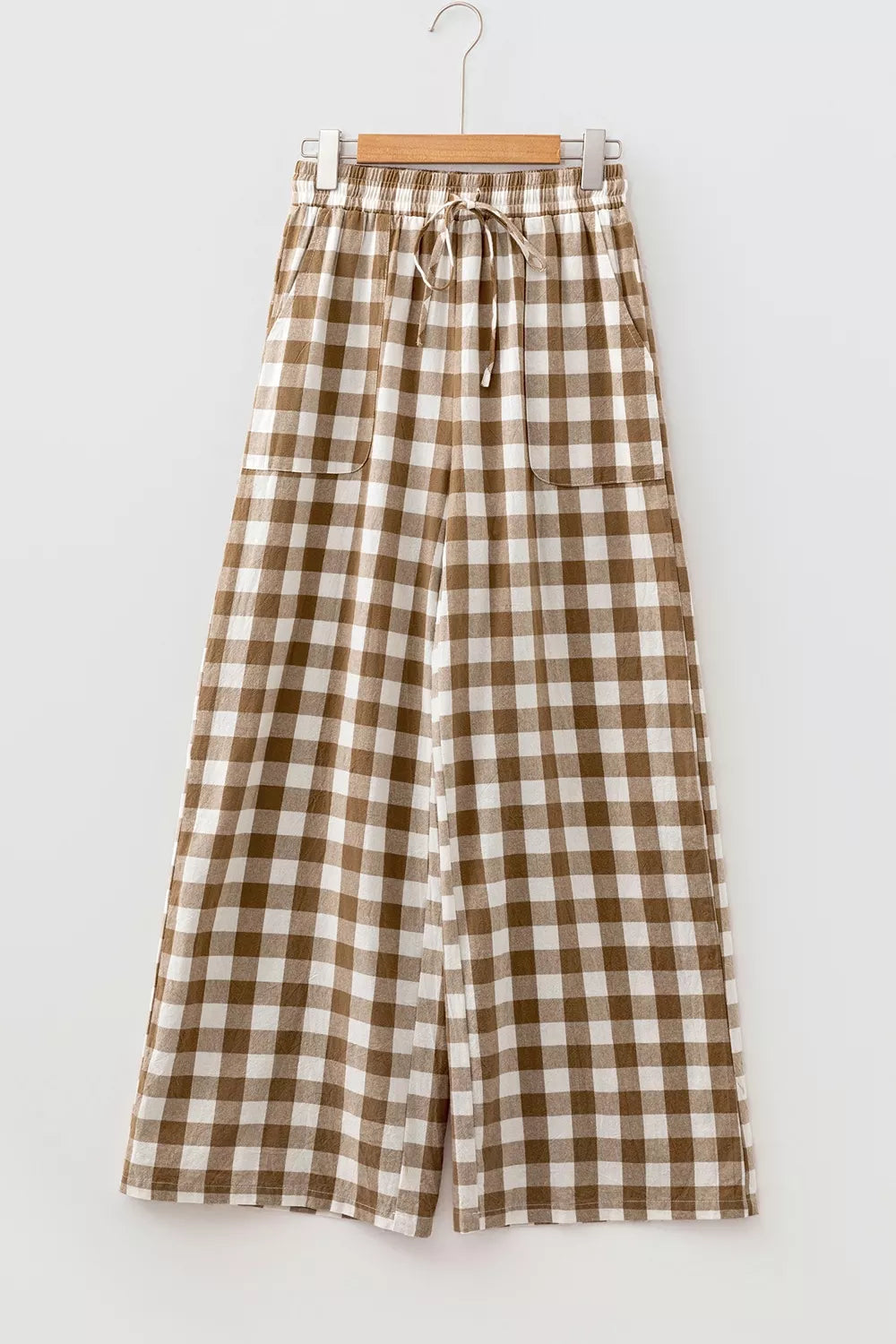 Brown gingham plaid wide leg pants hanging, front view with drawstring