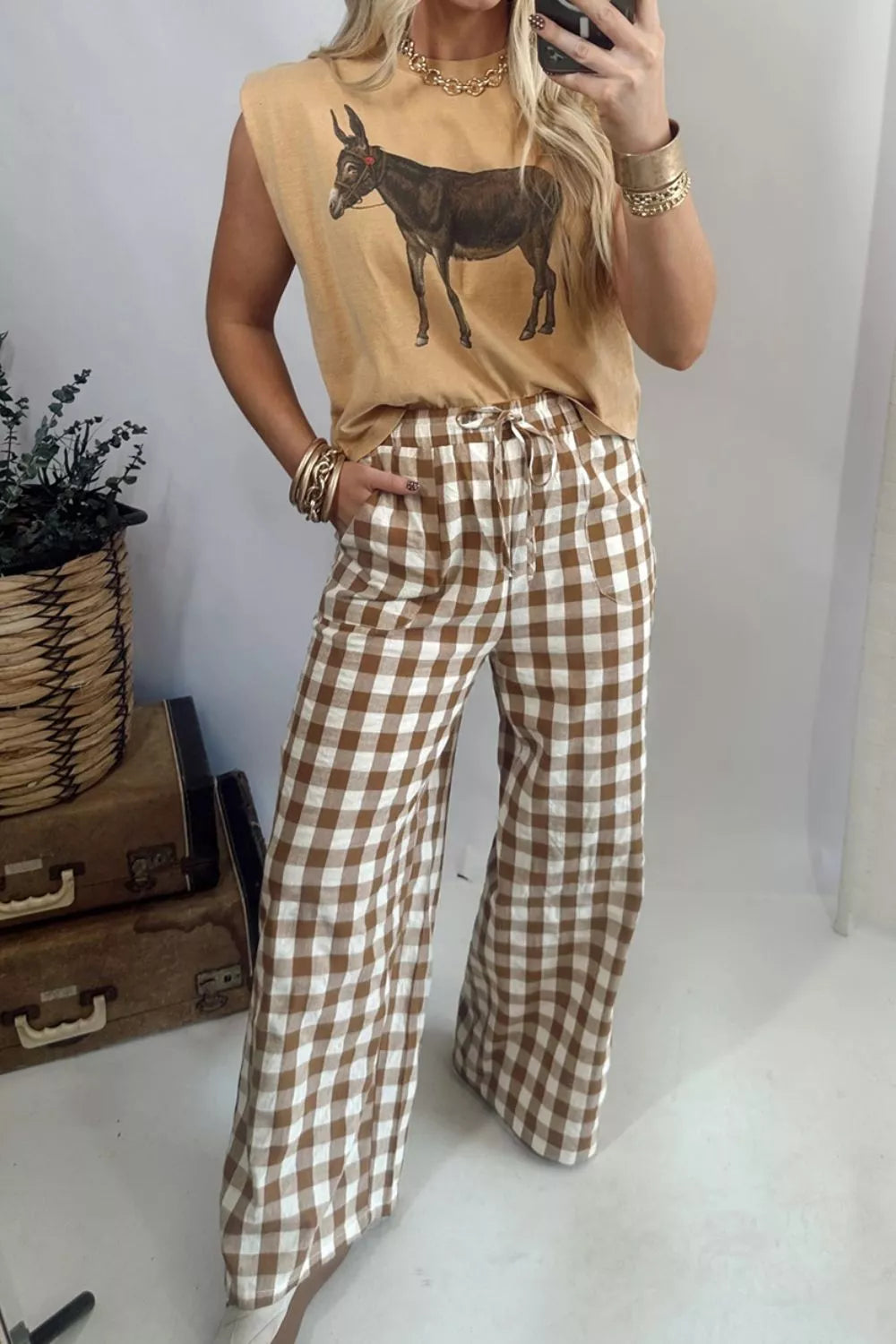 Brown gingham wide leg pants with a graphic tank top, selfie pose