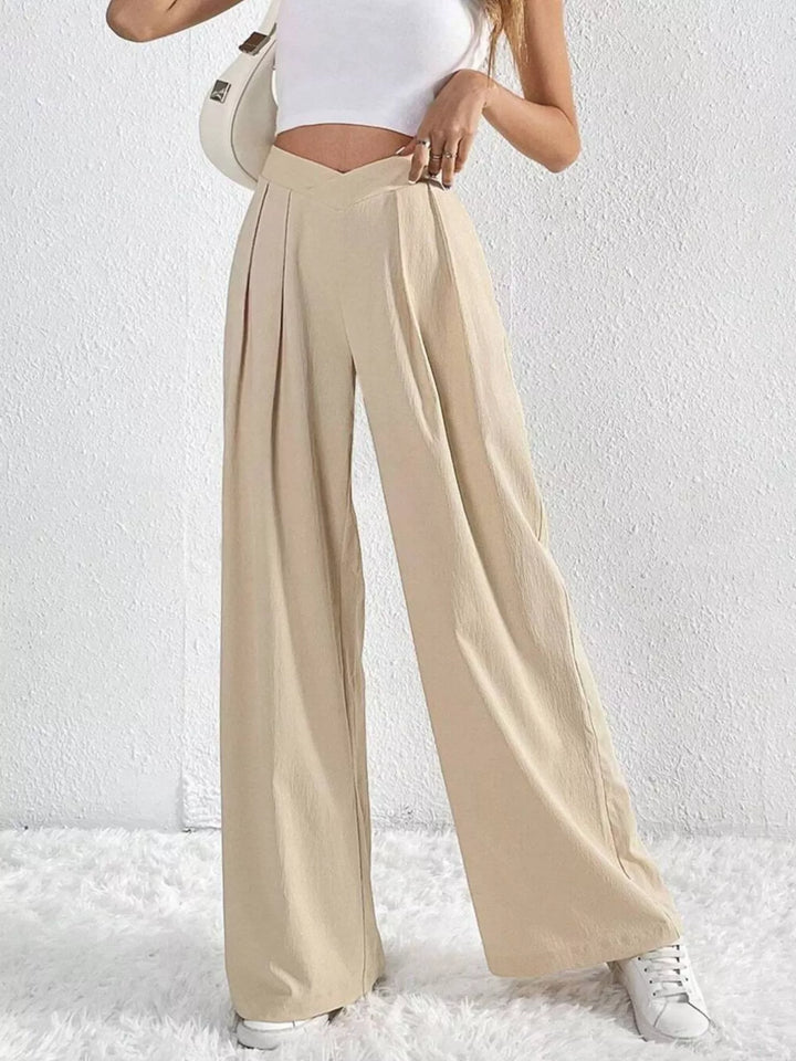 Beige pleated wide leg pants with V shaped waistband, front view