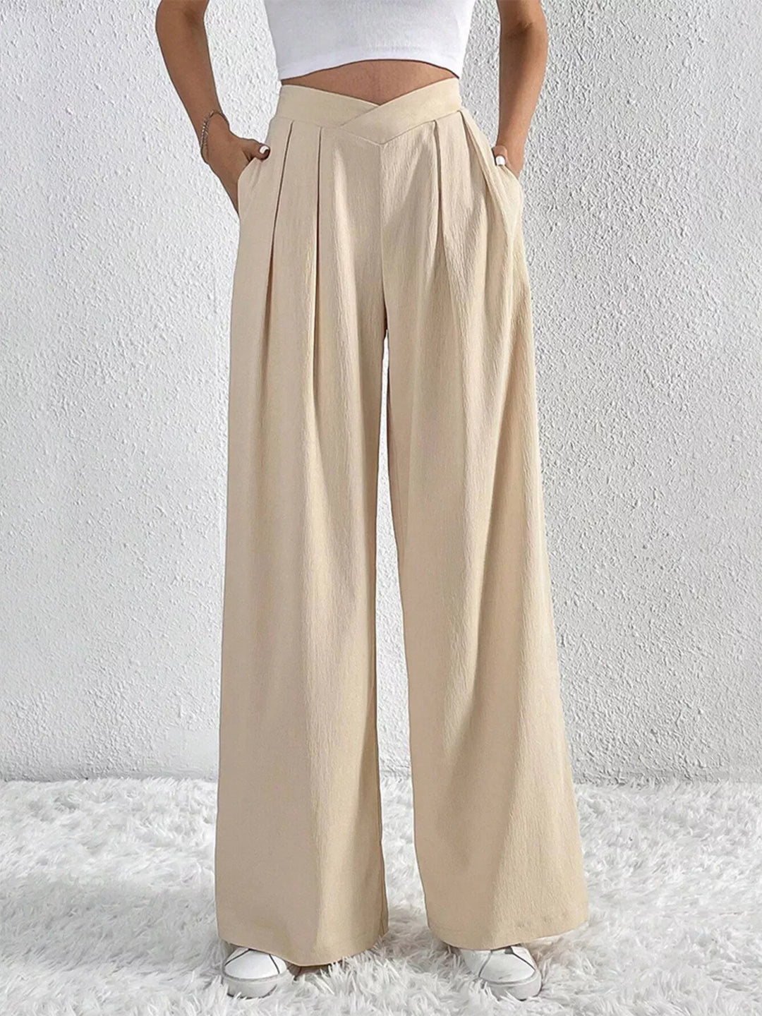 Beige high waist wide leg pants with side pockets, hand in pocket
