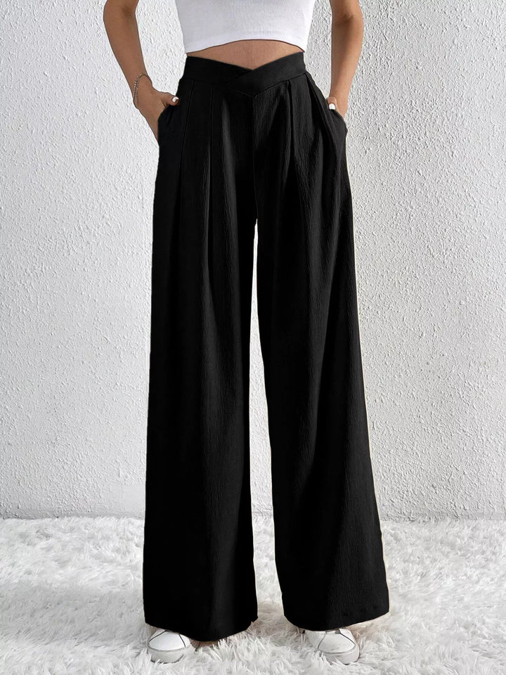 Black pleated pants with side pockets, closer front view of the waist