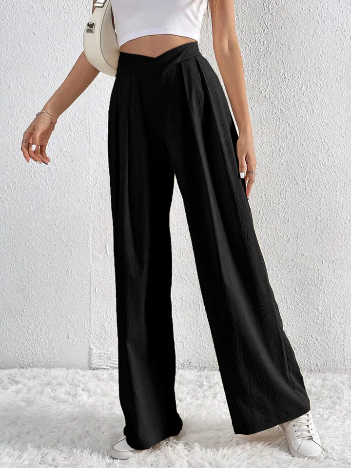 Black wide leg pants with V waistband, hand on hip pose