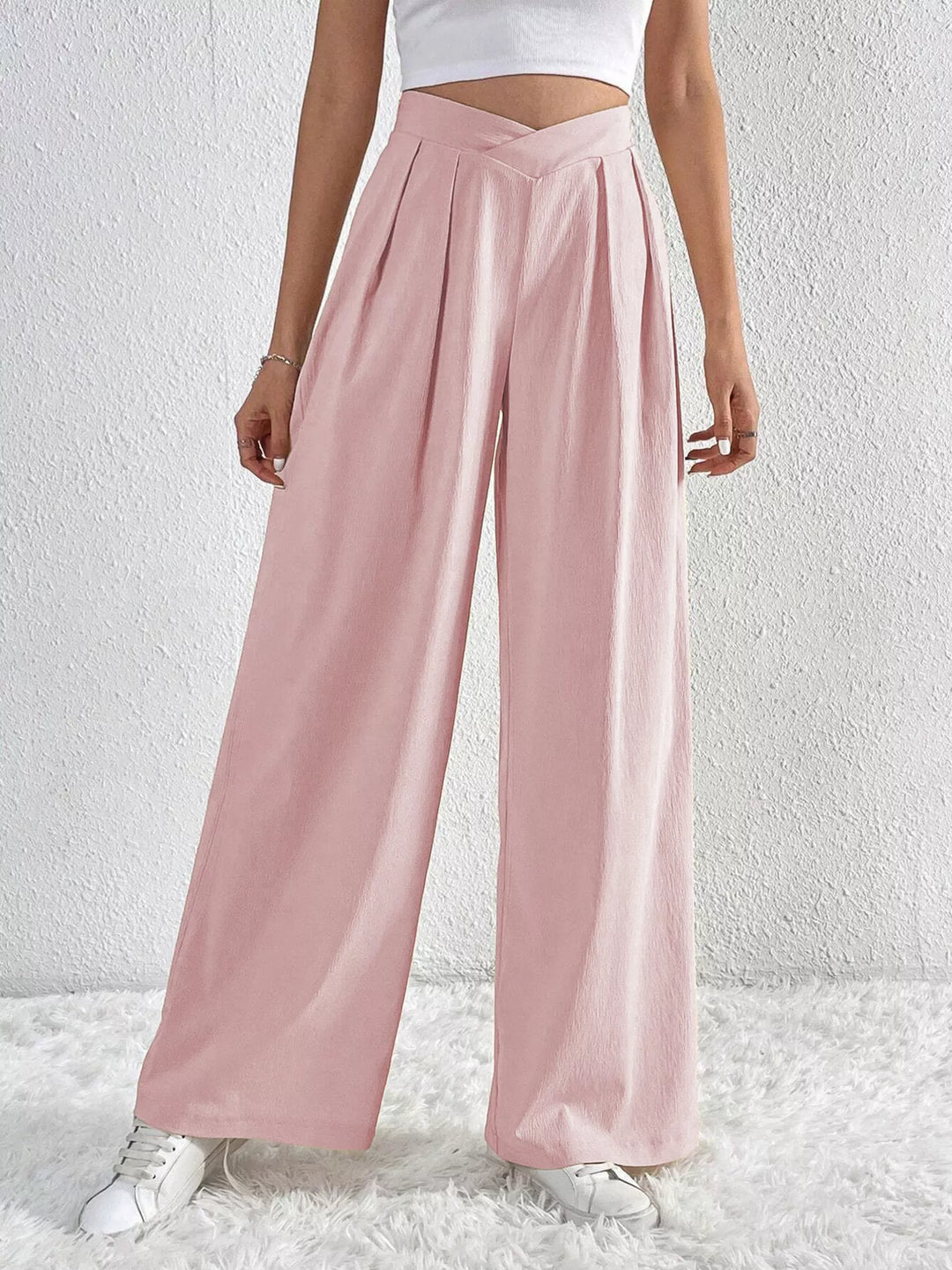 Light pink pleated wide leg pants with high waist, front view with sneakers