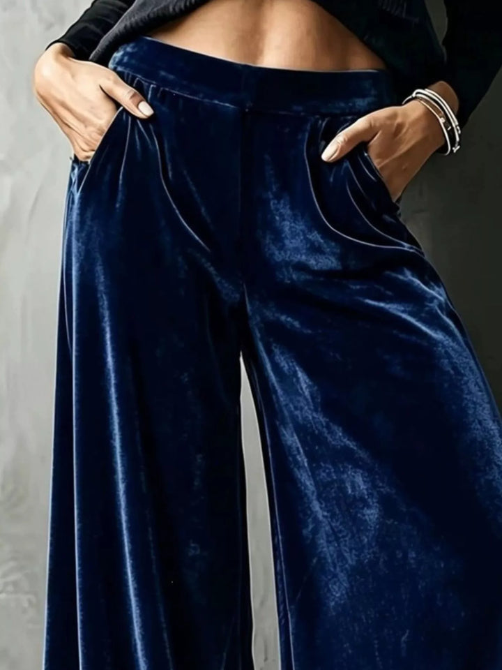 Close-up of navy wide leg pants showing pockets and the shiny drape