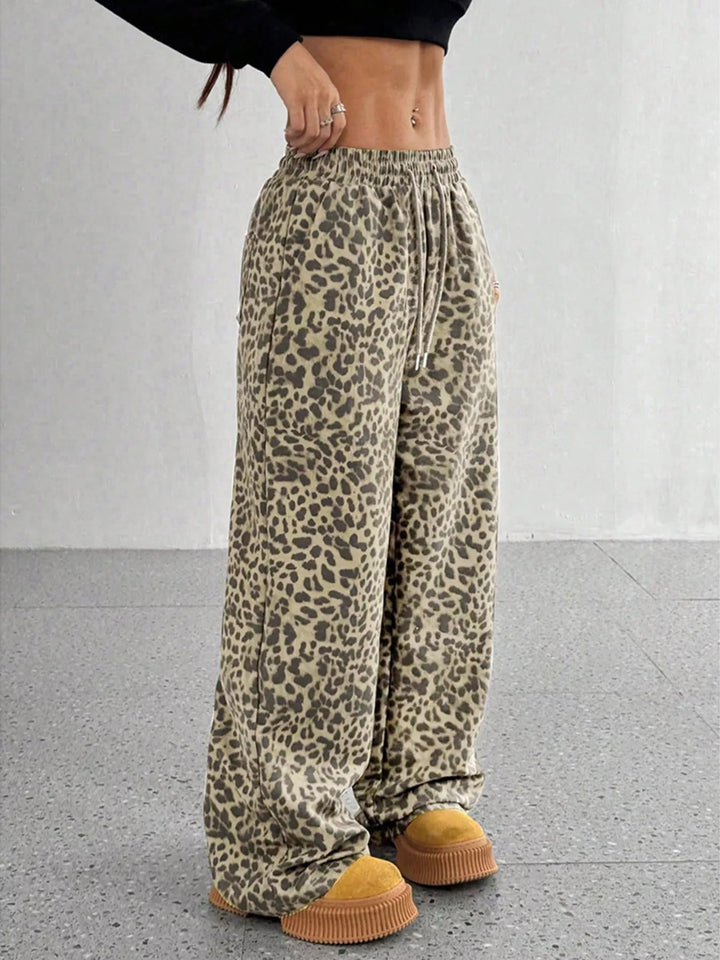Khaki leopard wide leg pants, angled view with a hand at the waist