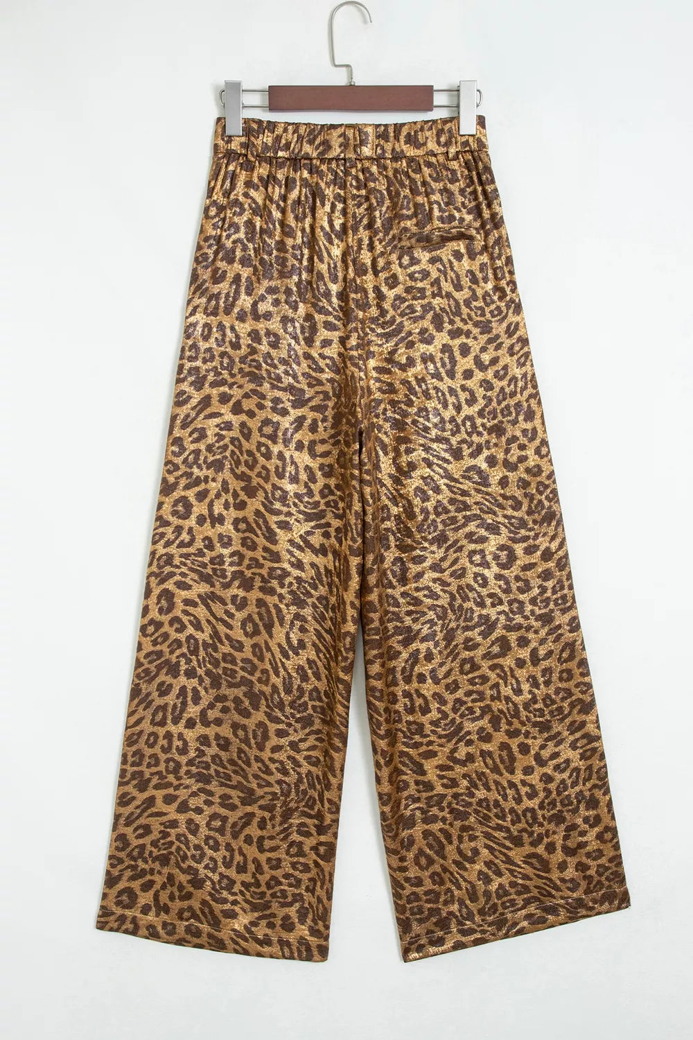 Leopard wide leg pants hanging, back view on light backdrop
