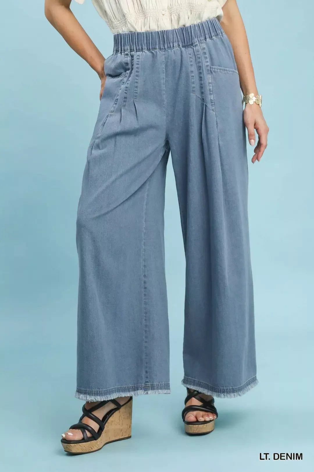 Women's wide leg pants in light denim, pull on pleated elastic waist, front view with wedges
