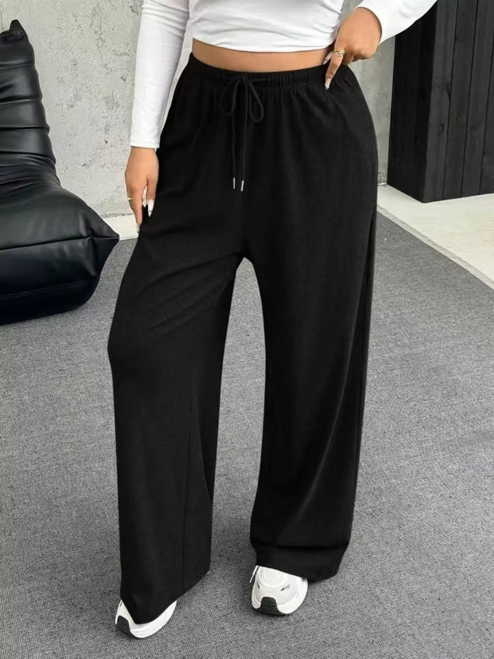 Black ribbed wide leg pants with drawstring waist, front view with white top