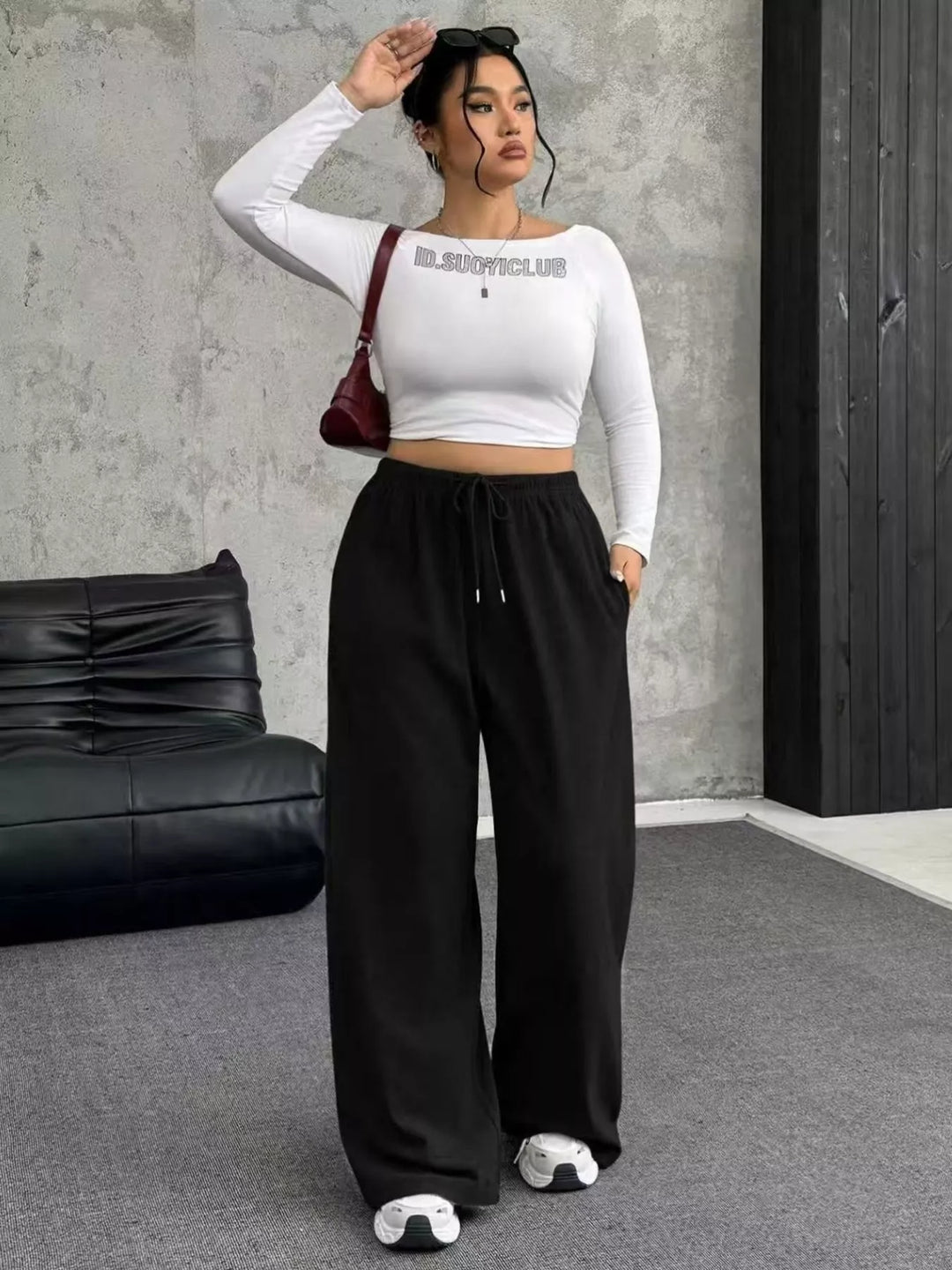 Black wide leg pants styled with a white crop top and red bag