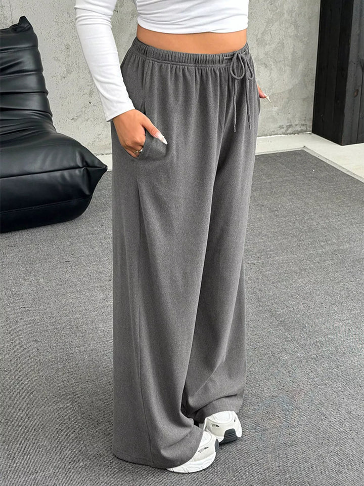 Gray ribbed drawstring pants with hand in pocket, side angle