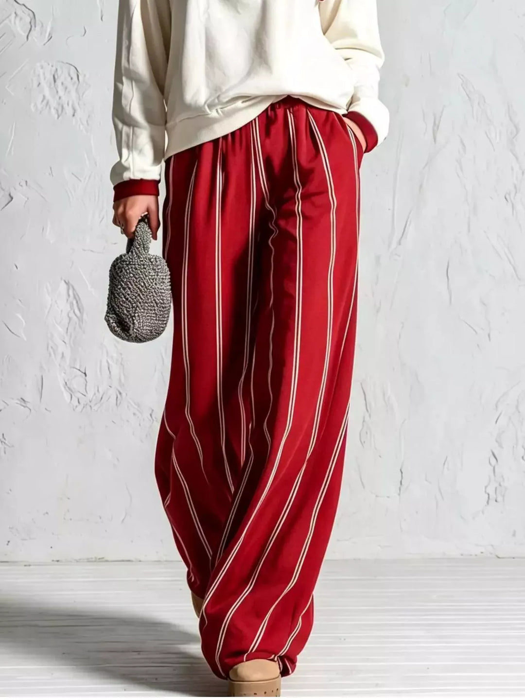Red pinstripe wide leg pants with cream pullover hem, lower body view