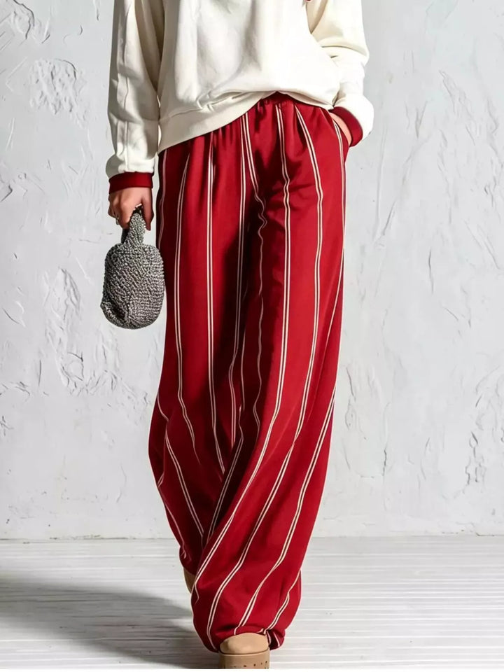 Red pinstripe wide leg pants with cream pullover hem, lower body view