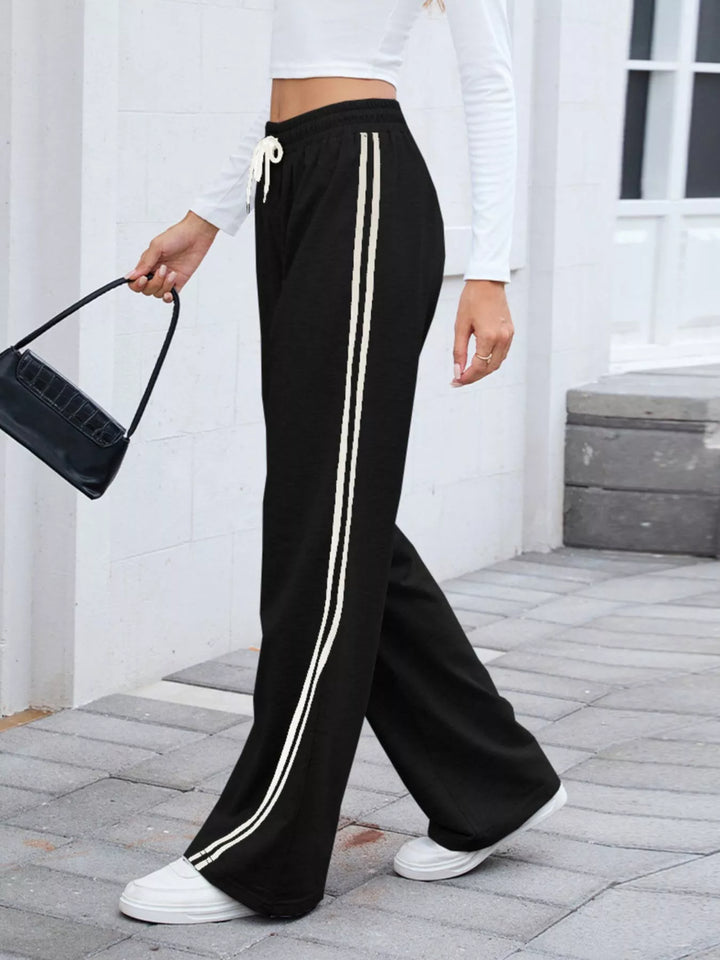 Black striped wide leg pants styled with a white crop top and baguette bag