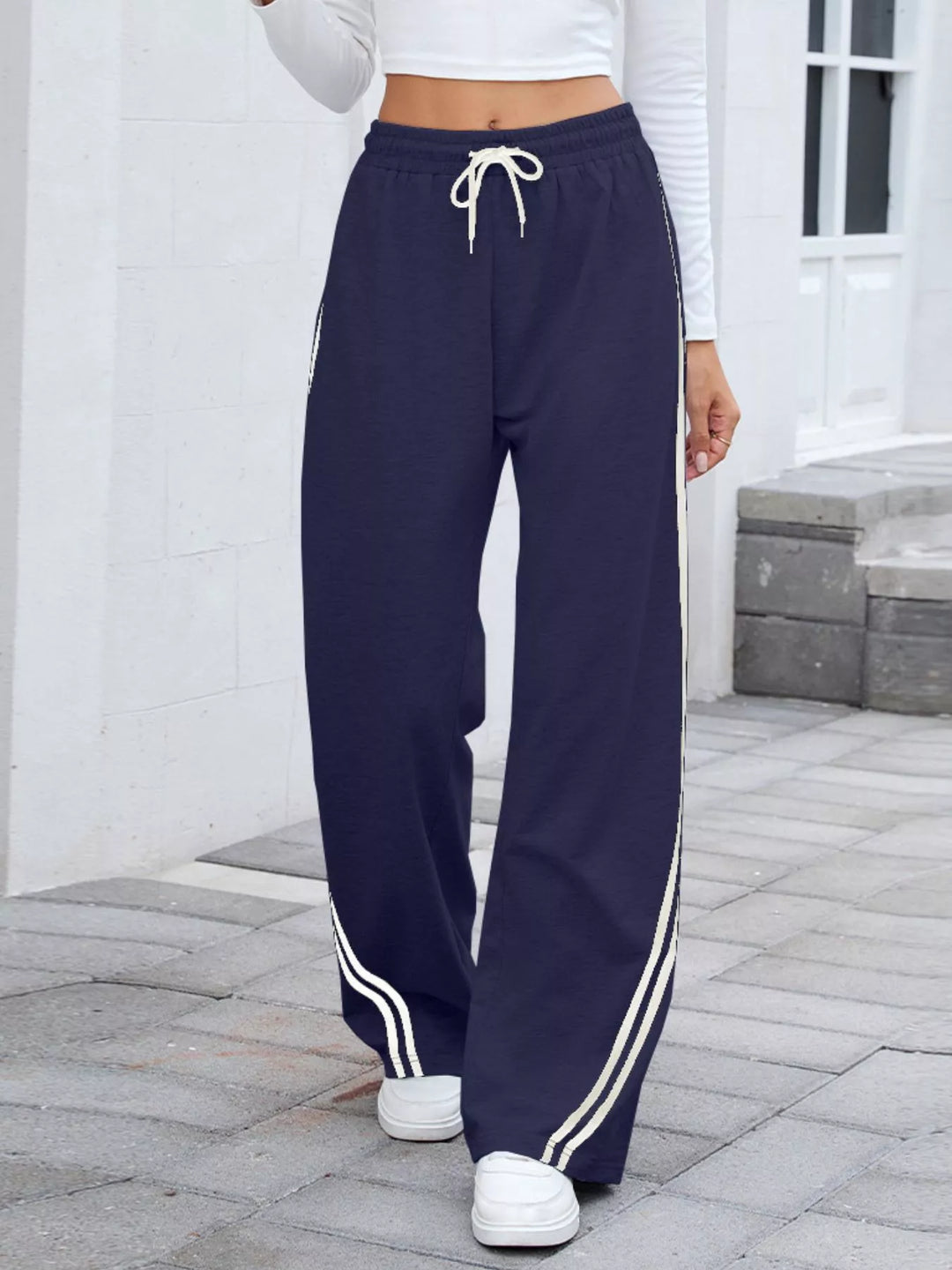 Navy wide leg pants with white side stripes and drawstring waist, front view