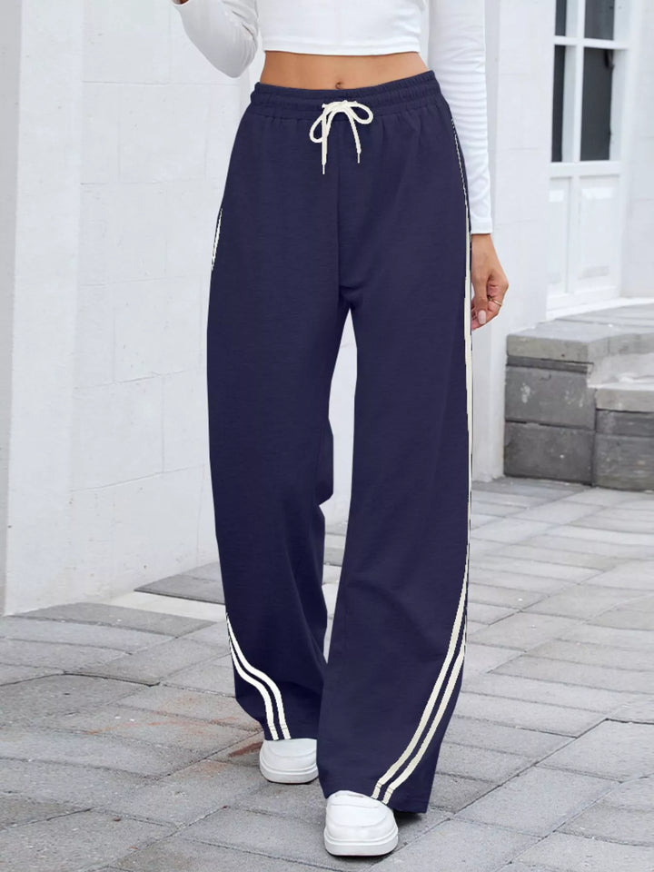 Navy wide leg pants with white side stripes and drawstring waist, front view