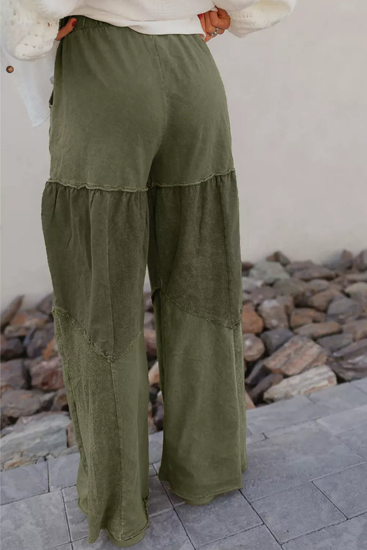 Detail of the tiered seams and wide legs on the olive green pants