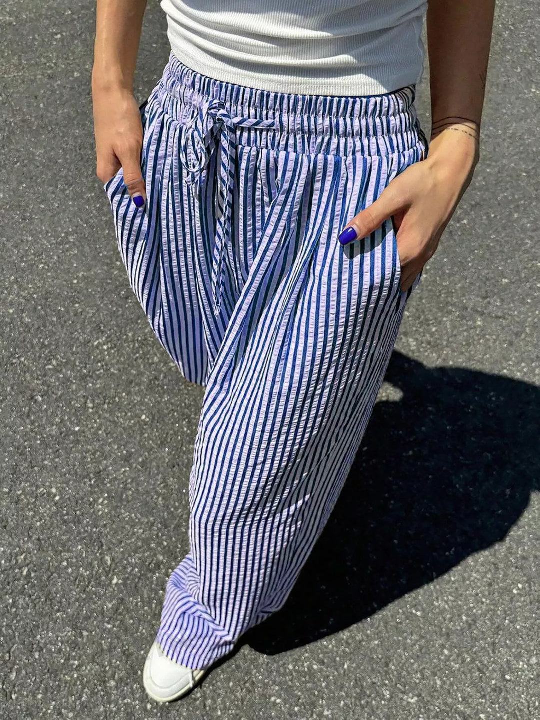 Close-up of the blue pinstripe pants drawstring bow and pocket