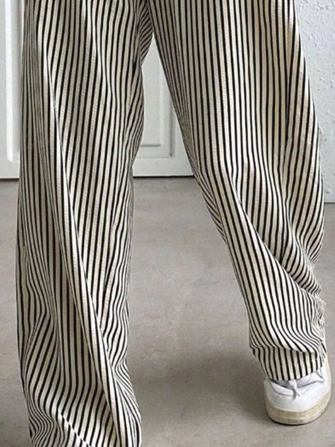 Close-up of the gray pinstripe wide legs and white sneakers