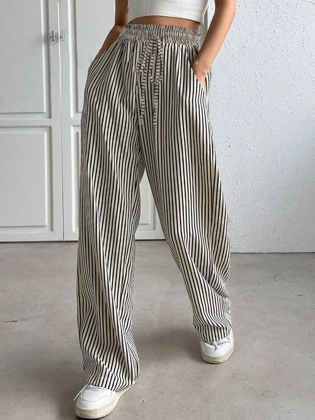 Gray pinstripe pants with elastic drawstring waist and sneakers