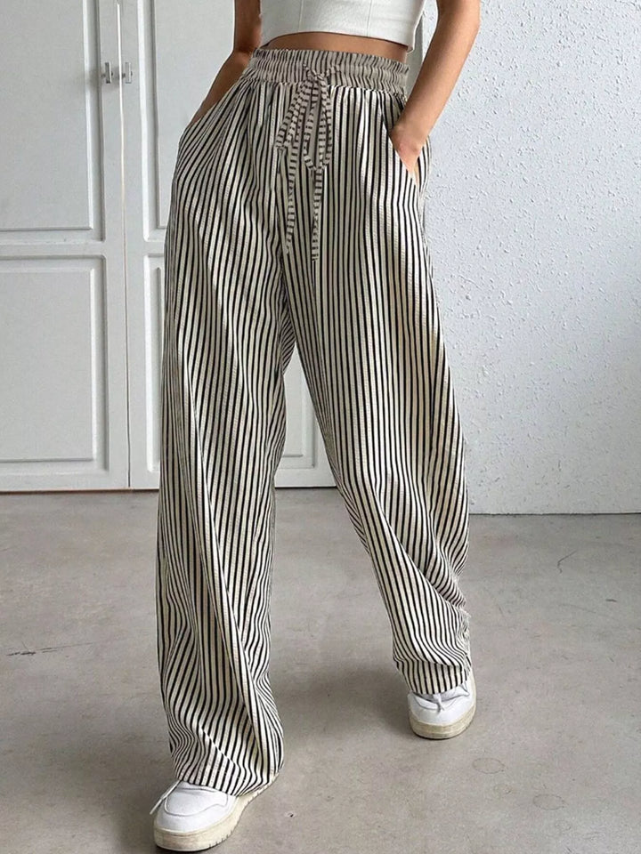 Gray pinstripe pants with elastic drawstring waist and sneakers