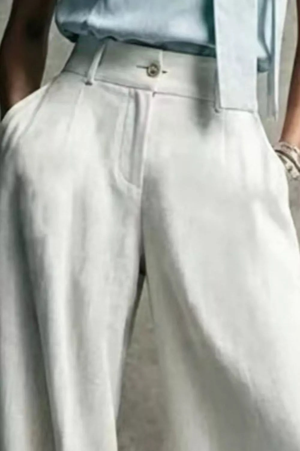 White high waist trousers, close-up of the button and zip front
