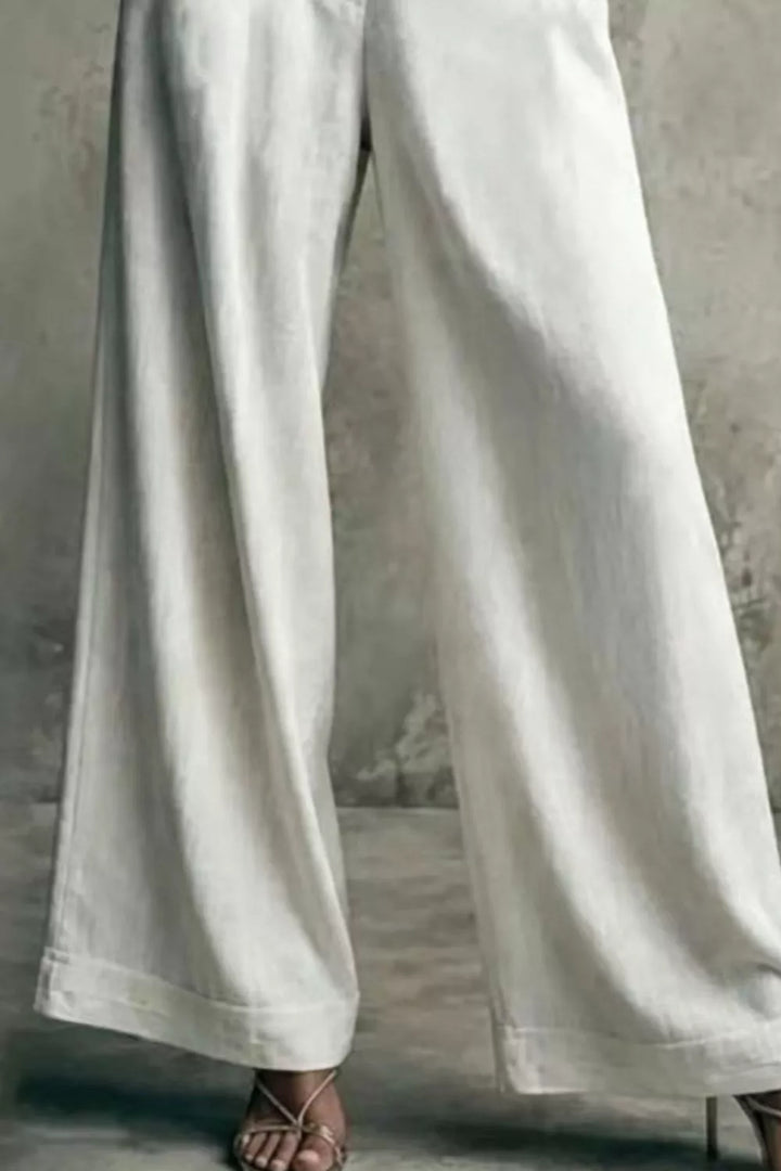 White pleated wide leg trousers shown from the hips down, front view