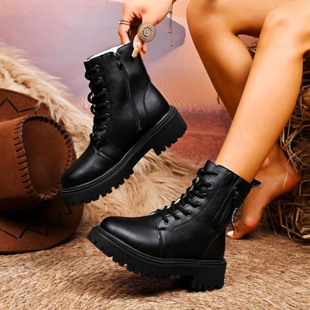 Black lace up platform ankle boots held up to show the side zipper