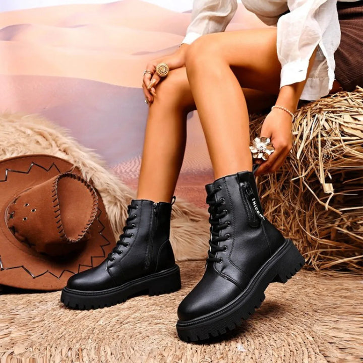 Black lace up winter boots styled with a white blouse and shorts