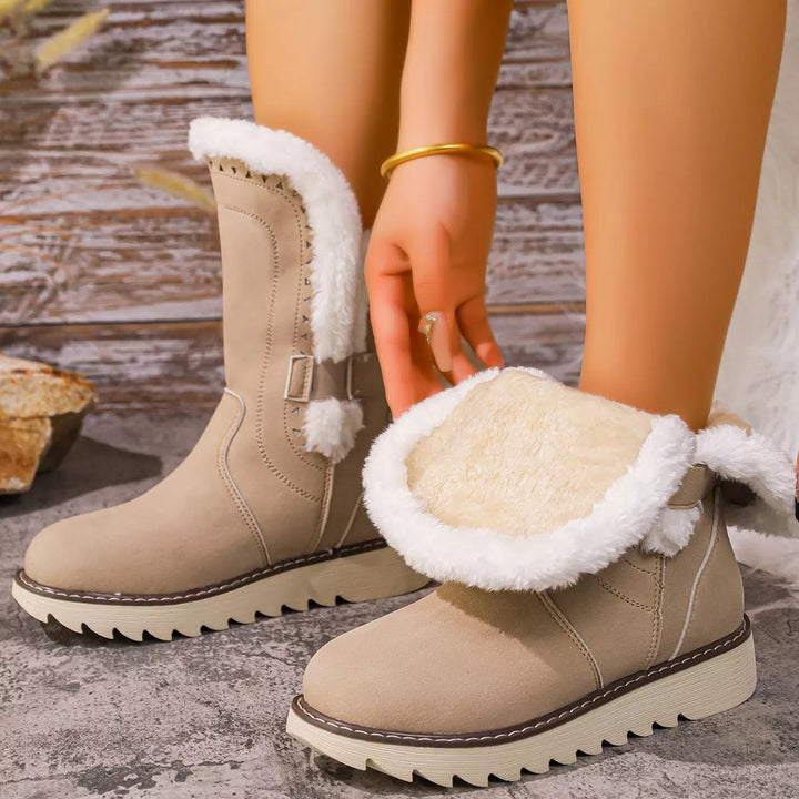Beige winter boot with the fur lined interior folded over by hand