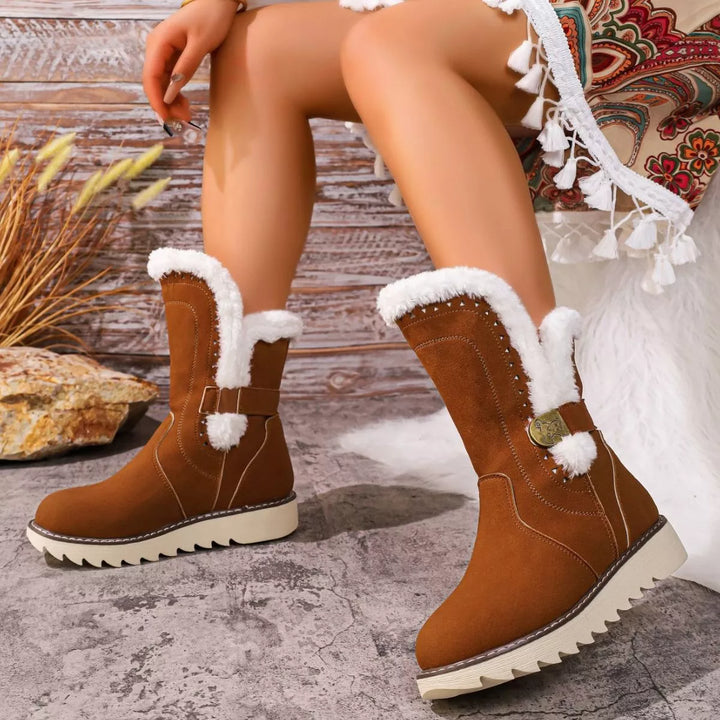 Side view of cognac faux fur trim boots on a rustic wood background
