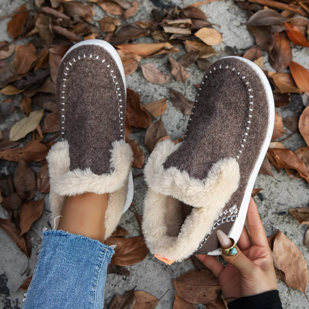 Coffee brown slip on ankle boots held in hand, top view of the pair