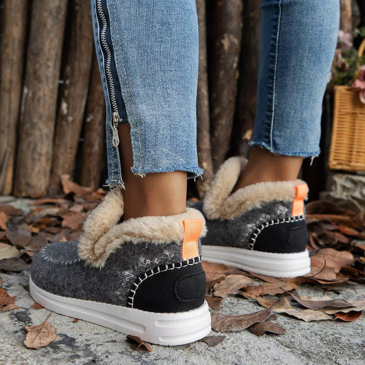 Gray slip on boots with black heel panel and orange pull tab, side view