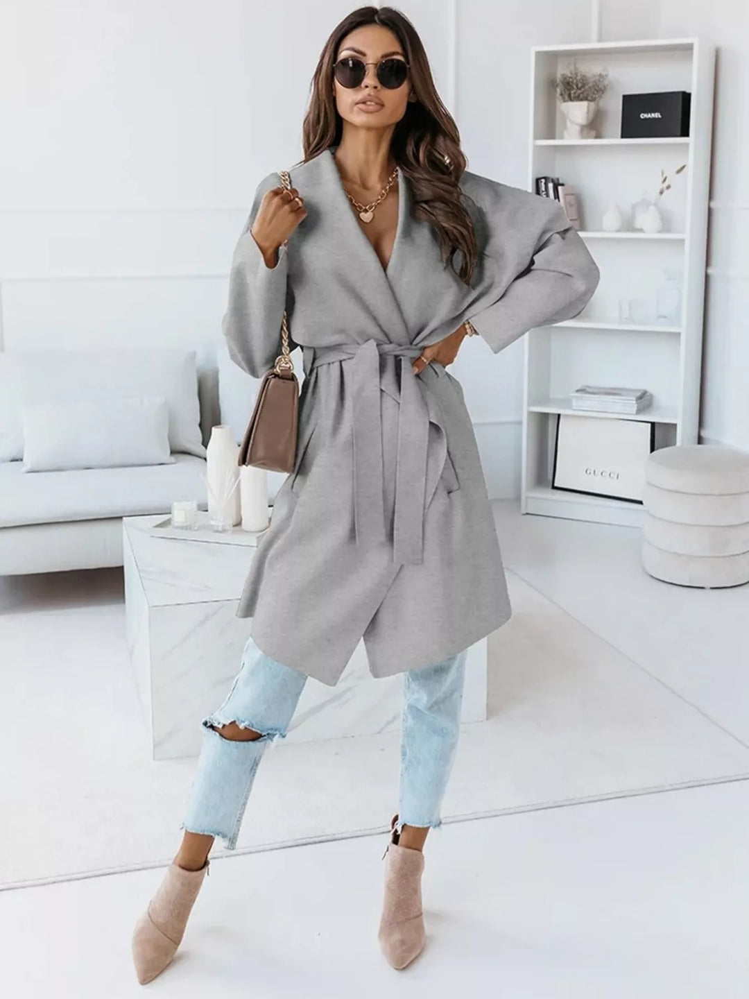 Full length gray belted coat with light jeans and heeled ankle boots