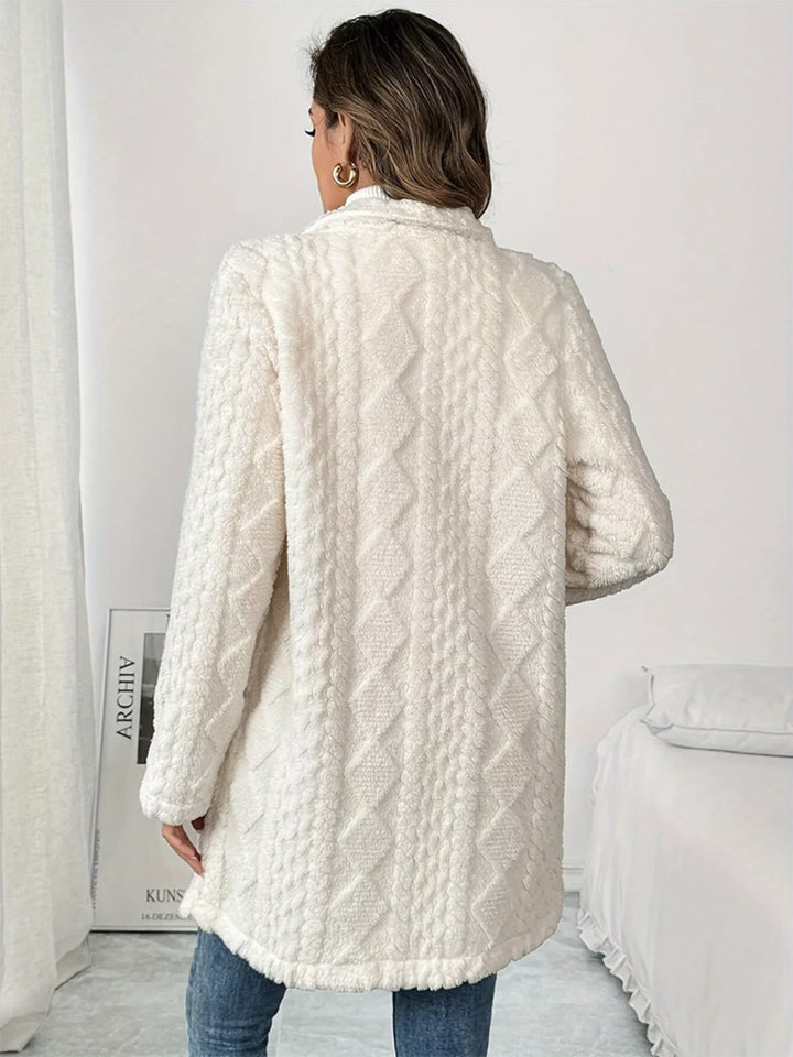 Back view of the ivory longline coat showing the diamond quilted texture