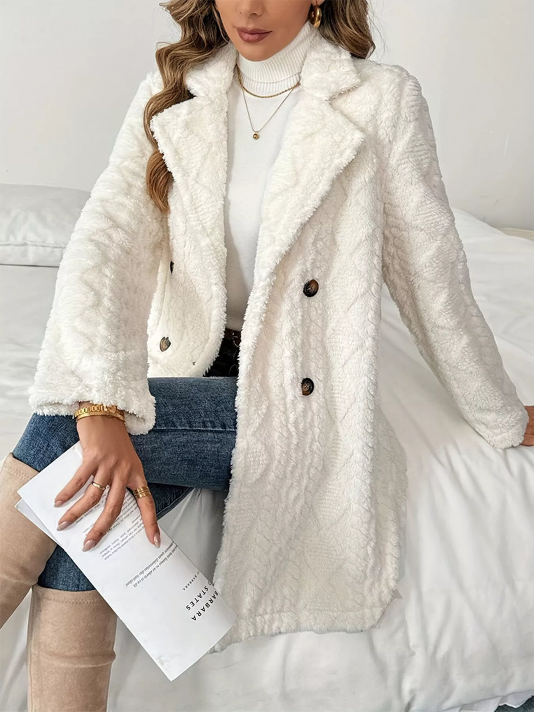 Seated pose in the ivory quilted winter coat with lapel collar and white top