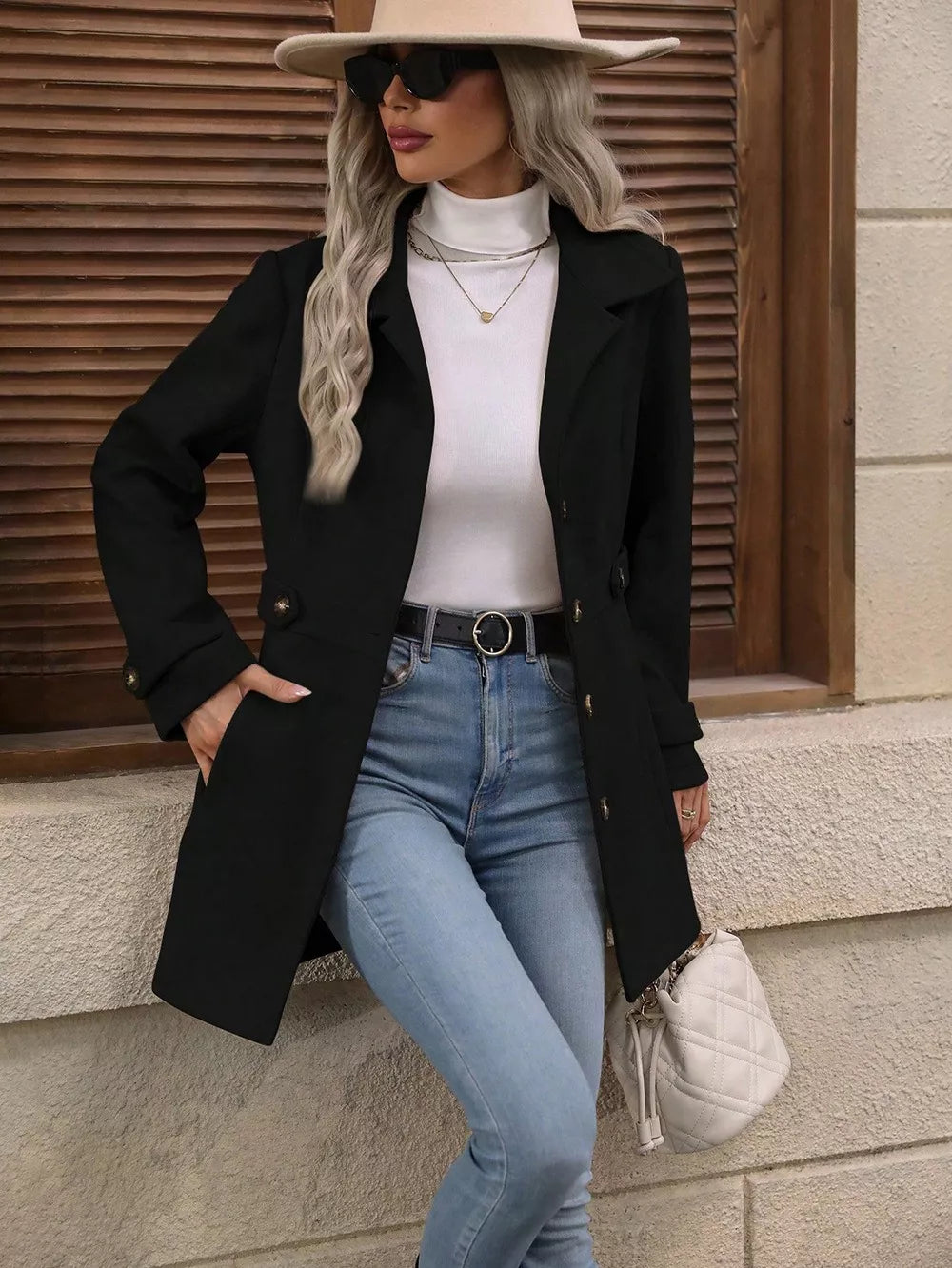 Black winter coat side view with hand in pocket and wide brim hat