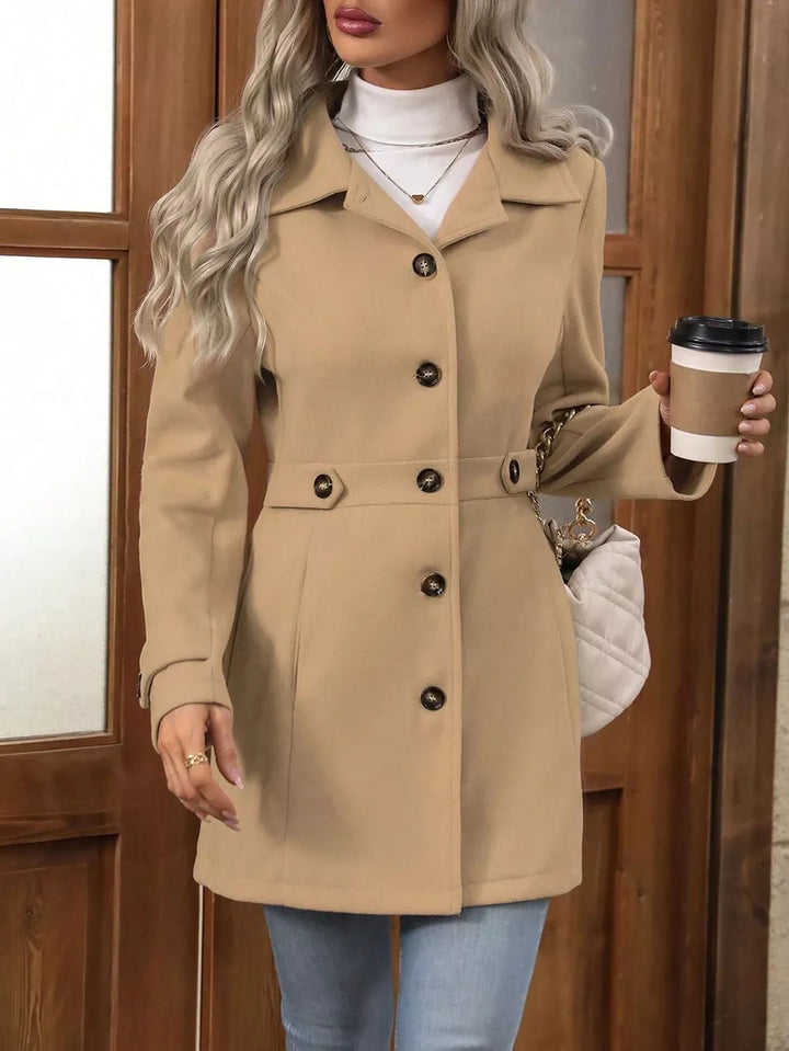 Camel winter coat with collared lapel and button front, paired with jeans and a turtleneck
