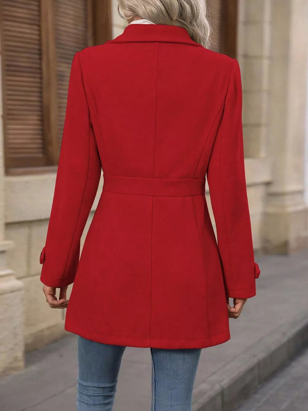 Back view of the red winter coat showing the tailored waist