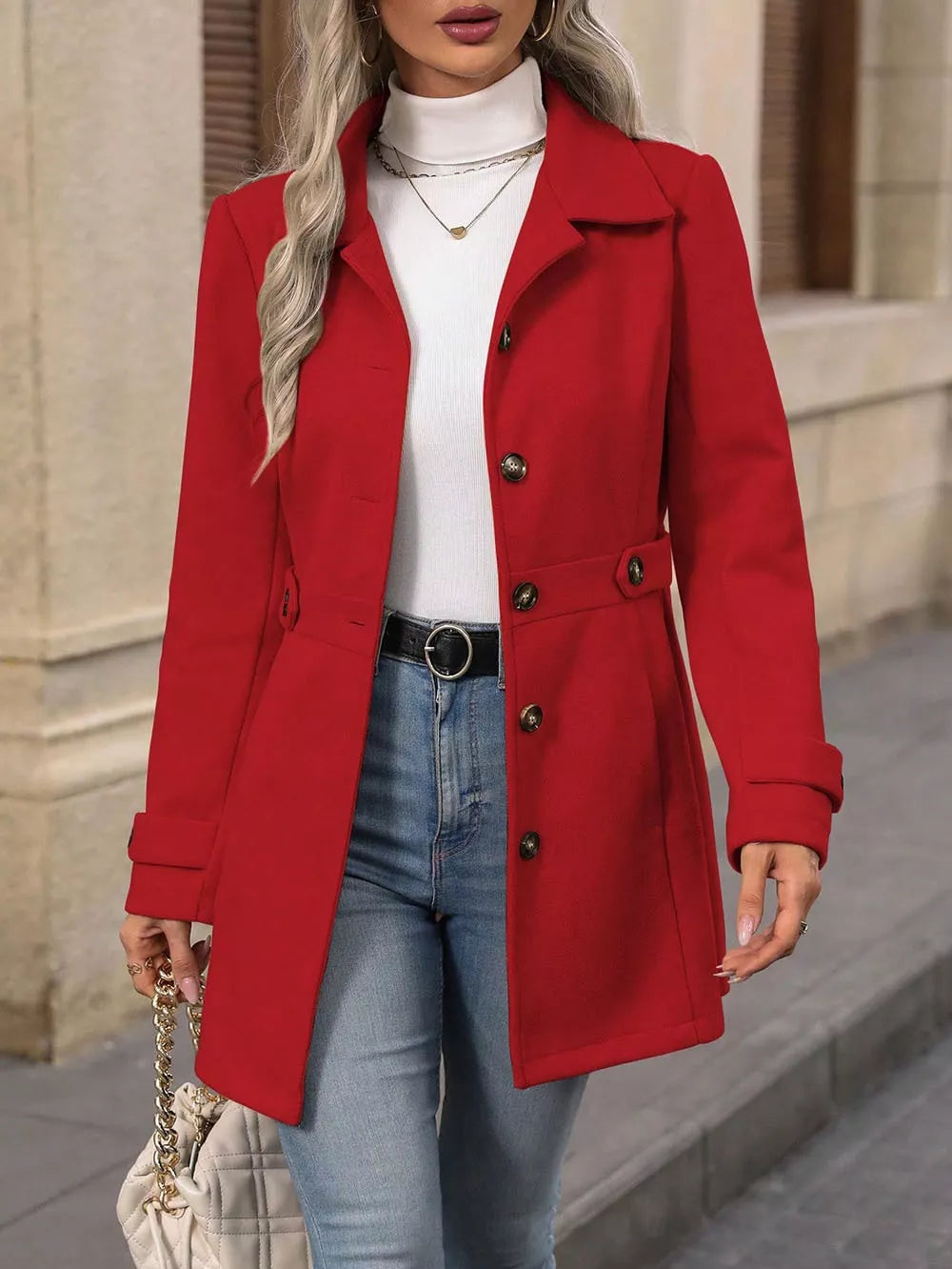 Red winter coat with collared lapel buttoned over a white turtleneck and jeans