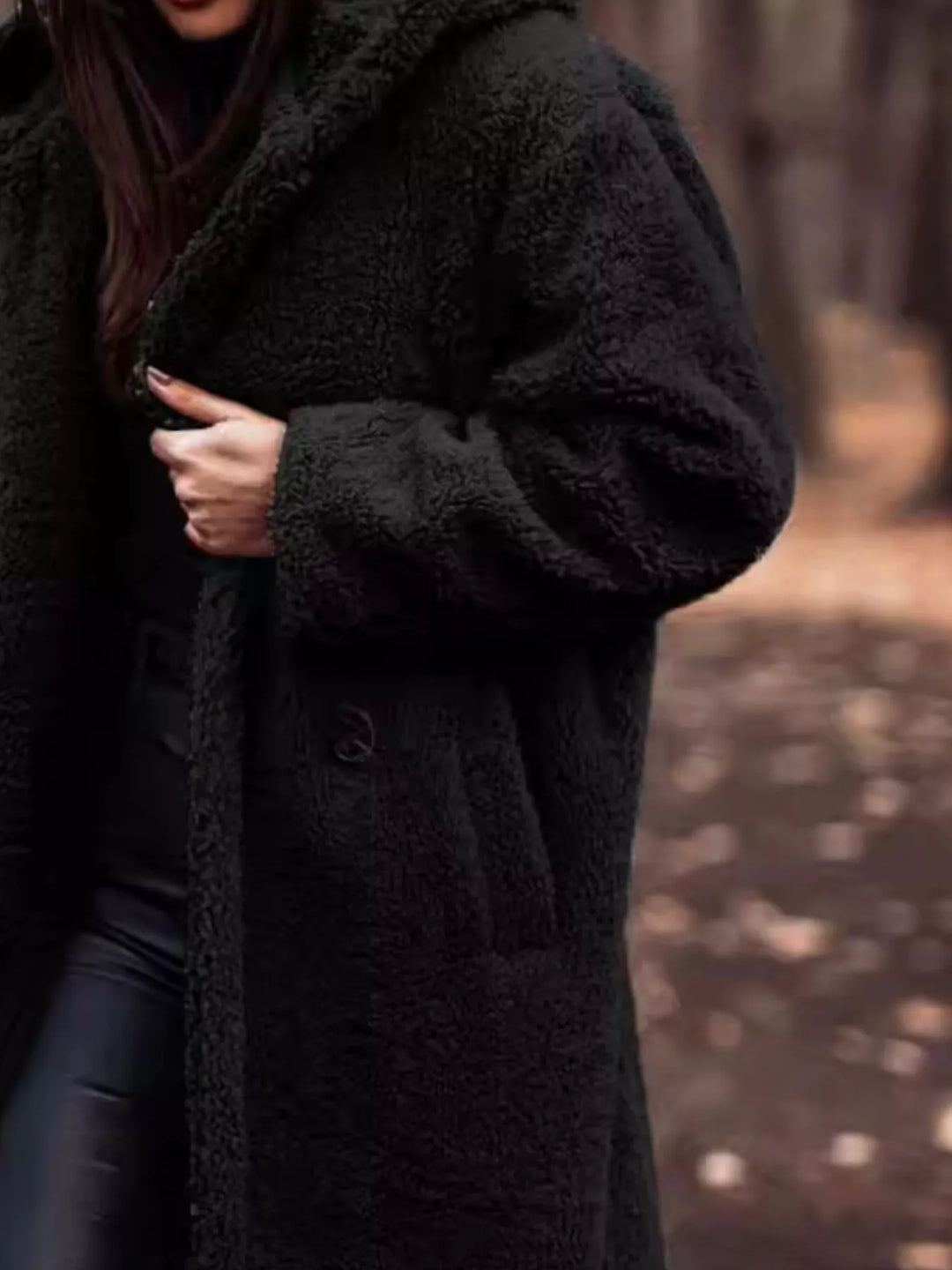 Close-up of the black plush hooded coat with hand on the lapel