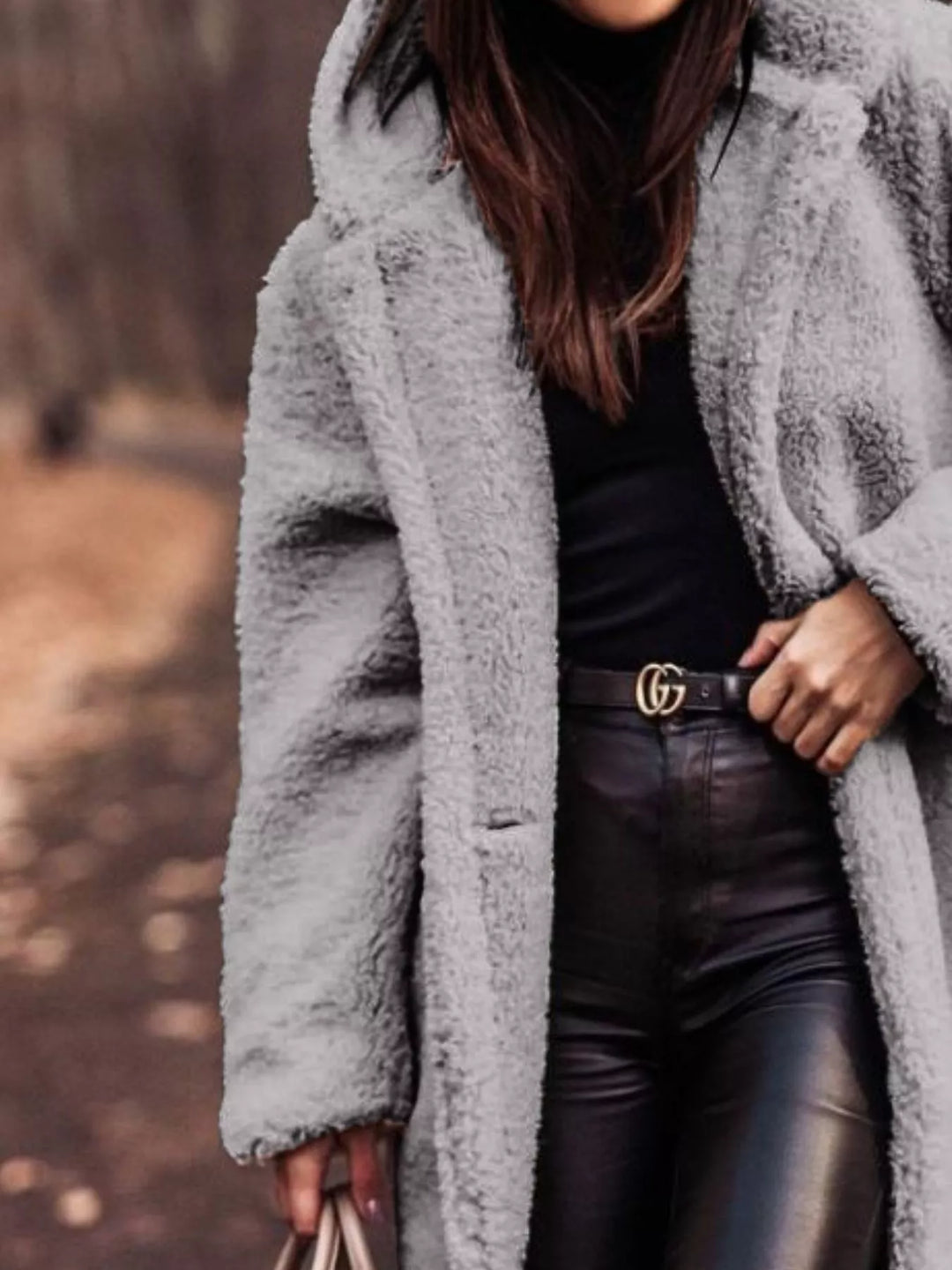 Close-up of the gray plush hooded coat with hand on the lapel