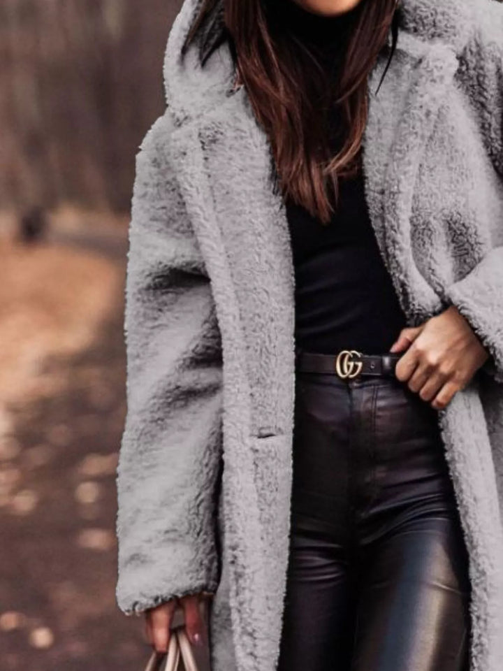 Close-up of the gray plush hooded coat with hand on the lapel
