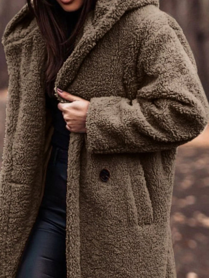 Close-up of the khaki plush hooded coat with hand on the lapel