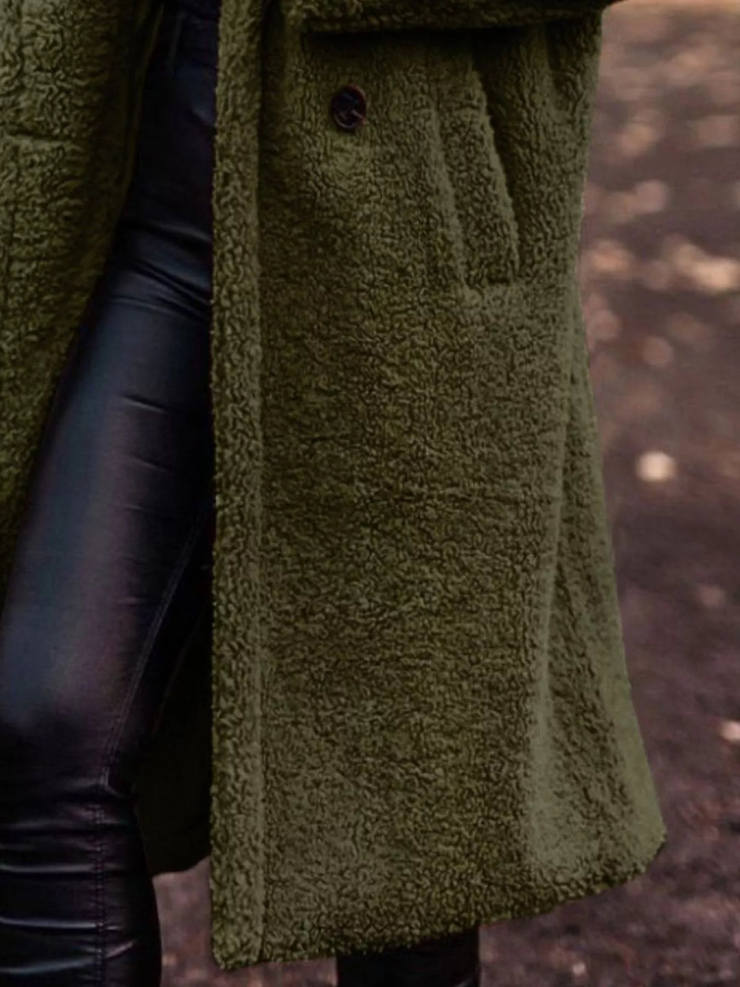 Close-up of the olive plush hooded coat with hand on the lapel